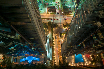 Fototapeta premium View from above of brightly illuminated high skyscraper hotel with swimming pool recreational area in downtown of Sunny Isles Beach city in Florida, USA. American tourist urban district at night