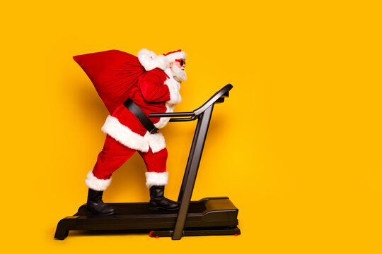 Profile side photo of fantasy character santa claus carrying gifts going empty space seasonal sale isolated on yellow color background