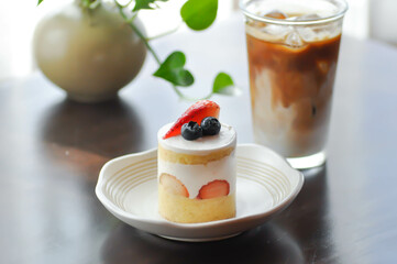 strawberry shortcake or strawberry cake with strawberry and blueberry topping and iced coffee
