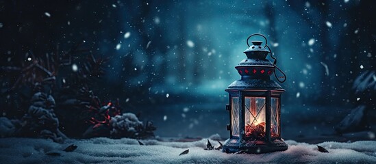  a lit lantern sitting in the middle of a snow covered field with a forest in the background and falling snow on the ground. - obrazy, fototapety, plakaty