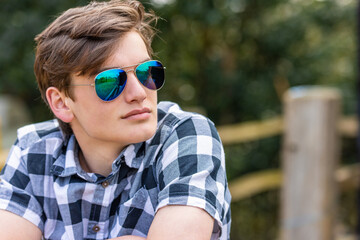 Young man teenager teen male adult outside wearing aviator sunglasses