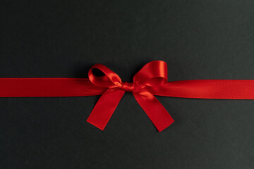 Red gift bow on black