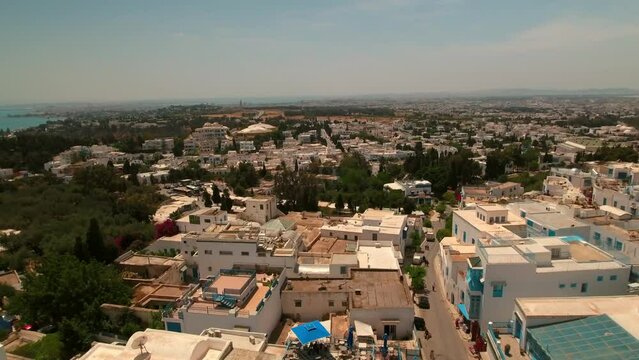 Aerial Ascending Shot Of Residential City Landscape By Sea Against Sky On Sunny Day - Mahdia, Tunisia