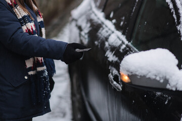 Woman open car using remote controller. Close up of woman hold car key. Winter outdoors