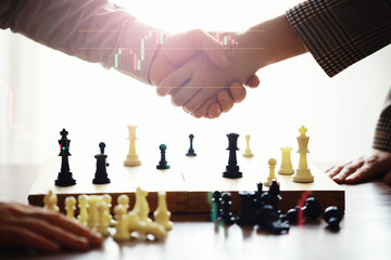 Black and White chess with player, Businessman and Businesswoman shaking hands after end game of...