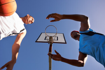 Men, player and basketball match at outdoor court or low angle of challenge team, dunk on rival....