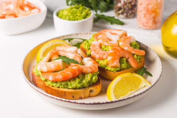 Shrimps on toast with avocado and lemon. Prawns. Breakfast concept. Bruschetta. 