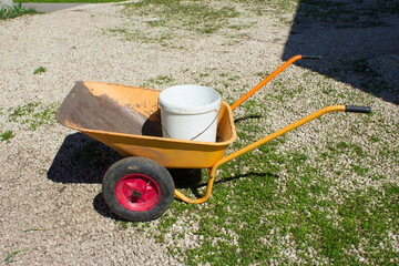 A garden wheelbarrow with a bucket.