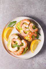 Shrimps on toast with avocado and lemon. Prawns. Breakfast concept. Bruschetta. 