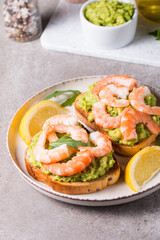 Shrimps on toast with avocado and lemon. Prawns. Breakfast concept. Bruschetta. 