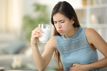 Woman suffering belly ache drinking milk