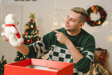  Family Exchanging And Opening Gifts Around Christmas Tree At Home. Christmas family portrait - family sitting on floor front of beautiful Christmas tree. MyRealHoliday. 
