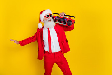 Fototapeta na wymiar Photo of positive cheerful person hold boombox dancing x-mas eve event isolated on yellow color background