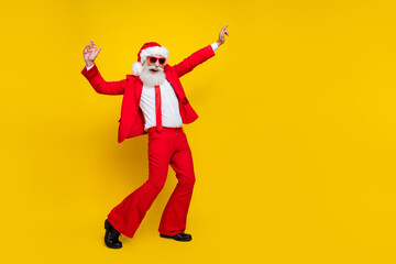 Fototapeta na wymiar Full length photo of cheerful cool santa dressed red suit tie dancing having fun discotheque empty space isolated yellow color background