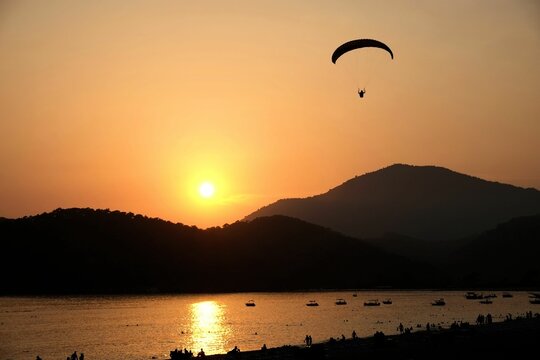 A paraglider coming into land at sunset olu deniz beach