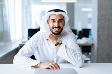 Handsome man with dish dasha working in his business office of Dubai. Portraits of a successful...