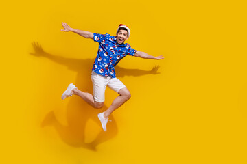 Fototapeta na wymiar Full body photo of energetic overjoyed man arms wings jump fly empty space isolated on yellow color background