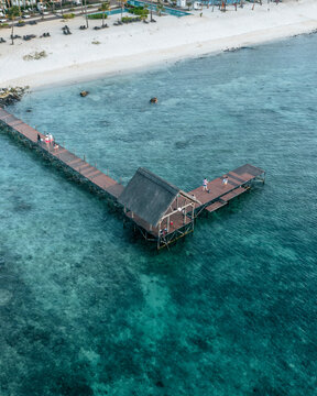 Aerial view of people on a jetty along the coastline in Pointe aux Piments, Pamplemousses, Mauritius.
