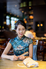 Woman wear traditional cheongsam in the restaurant
