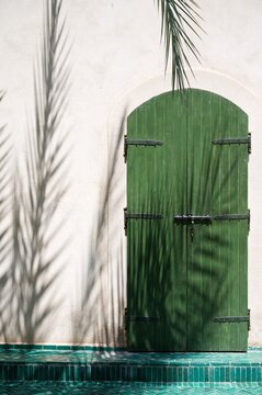 Porte d'un palais marocain avec ombre de palmier, Marrakech