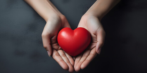 Female hand holding red heart isolated on blue background 