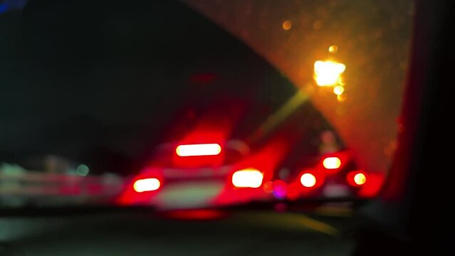 Defocused background of big city traffic from inside car. Blurry lights of automobiles. POV passenger view of night road. Film grain pixel texture. Soft focus. Live camera. Blur.