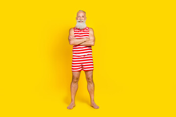 Full length photo of good mood funny elderly guy dressed striped red swimsuit arms folded empty...