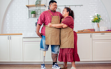 Portrait of asian couple including happy wife who has husband with disable prosthetic leg, hug with...
