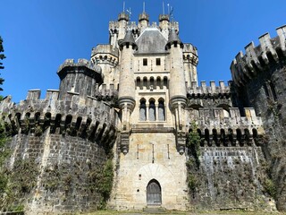 Fototapeta na wymiar Low angle shot of a castle with a blue sky background
