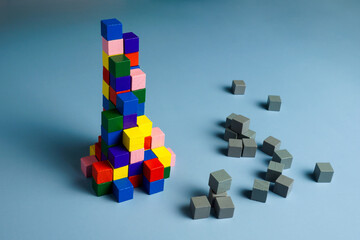 Teamwork, unity and diversity. Gray cubes and a pyramid of multi-colored ones.