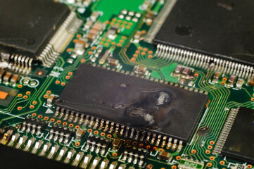 Electronic integrated circuit (IC) on a computer PCB after suffering a catastrophic static discharge and burn out