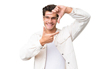 Young handsome caucasian man over isolated background focusing face. Framing symbol