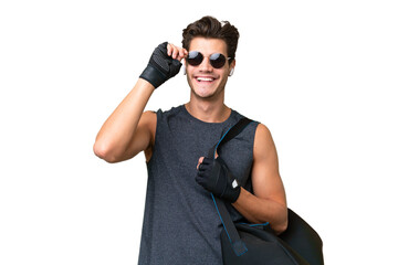 Young sport caucasian man with sport bag over over isolated background with glasses and happy