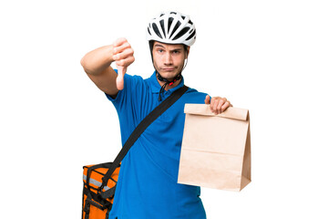 Young caucasian man taking a bag of takeaway food over isolated background showing thumb down with...