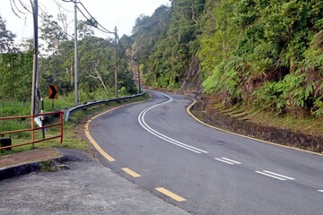 A zigzag asphalt road along a steep cliff.
