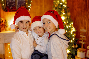 Fototapeta na wymiar Happy family, children and mom, taking family pictures in a cozy christmas studio