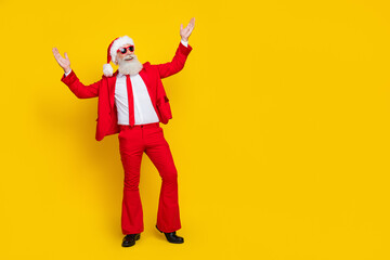 Fototapeta na wymiar Full length photo of handsome impressed man pensioner dressed red suit santa hat looking empty space isolated yellow color background