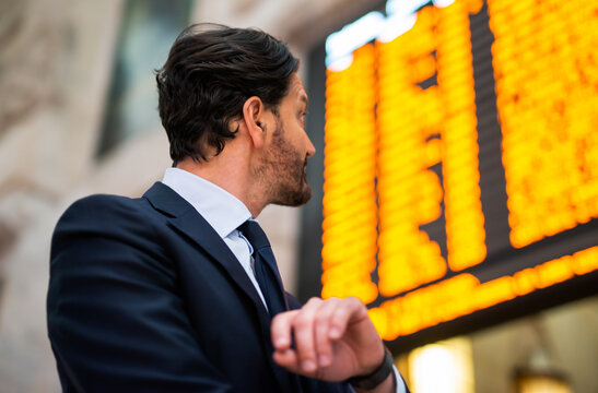 Man checking time in front of a timetable