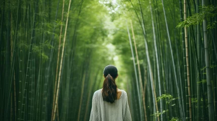 Rolgordijnen woman walking in bamboo forest © mimadeo