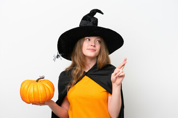Young pretty woman costume as witch holding a pumpkin isolated on white background with fingers crossing and wishing the best