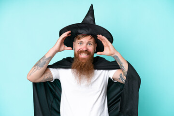 Young wizard in halloween isolated on blue background with surprise expression