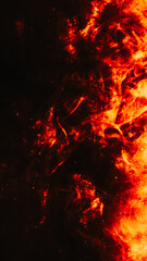 Fototapeta na wymiar Bokeh sparks background. Bonfire flame. Orange smoke with golden glitter flow liquid glowing paint spreading in black abstract explosion art.