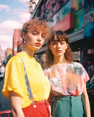 Obraz premium Generative ai two young and beautiful woman gracefully posing on the city streets