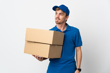 Young delivery blonde man isolated on white background looking to the side and smiling