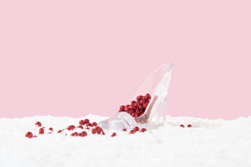 Ladies shoe with glittering red pearls on snow. Minimal celebration, party concept. Pastel pink...