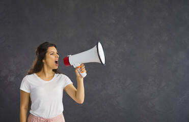 Don't miss it. Casual woman who uses a megaphone to announce advertising information or present...
