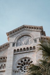 Obraz premium Low angle shot of Saint Nicholas Cathedral in Monaco behind a palm tree