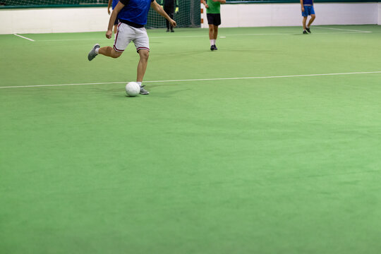 Players in action on five a side match. Sport concept. Indoors hall with artificial turf.