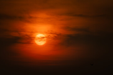 Dramatic red black sunset, Sun behind foggy clouds, tropical sky, very close up photo