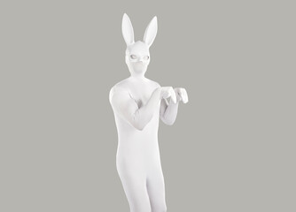Funny human model pretends to be a bunny. Man disguised in a white skin tight spandex bodysuit costume and long eared playboy rabbit mask hopping like a rabbit on a gray color studio background